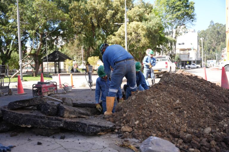 Cuadrilla de empleados de EMPODUITAMA y un hombre realizando labores de excavación y obras en la vía pública, cerca al Parque del Carmen.